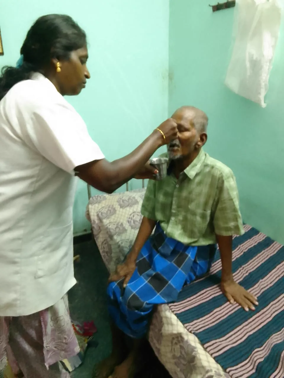 A caregiver grooming a resident in the courtyard
